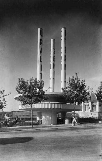 Pabellon de la empresa Uralita en la Exposicion Internacional de Barcelona de 1929. Tenía una base redondeada y tres altos tubos verticales, en cada uno de los cuales tenía escrito el nombre de una de las tres principales marcas que comercializaban material de fibrocimiento por todo el mundo.